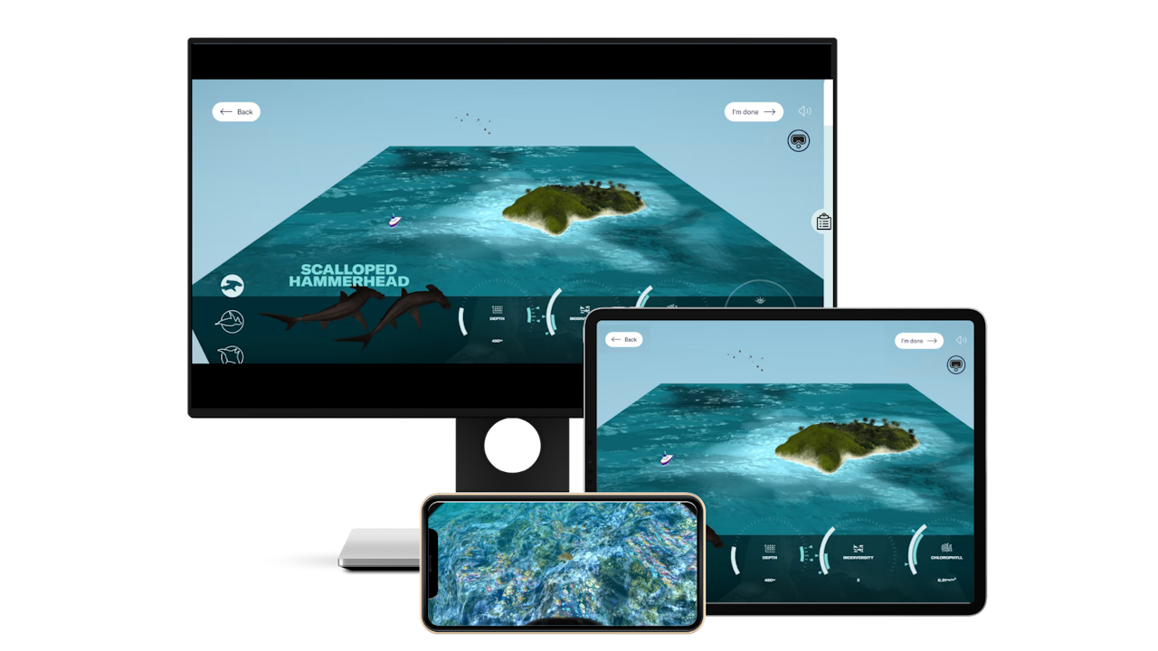 The Dive Detective VR experience shown on a computer screen, tablet, and iPhone. The computer screen and tablet shows a map of the ocean surrounding Cocos island and the experience’s information panel. The iPhone shows an underwater view from the experience. - click to enlarge The Dive Detective VR experience shown on a computer screen, tablet, and iPhone. The computer screen and tablet shows a map of the ocean surrounding Cocos island and the experience’s information panel. The iPhone shows an underwater view from the experience.