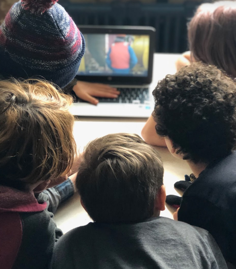 Children gathered around a laptop. - click to enlarge Children gathered around a laptop.