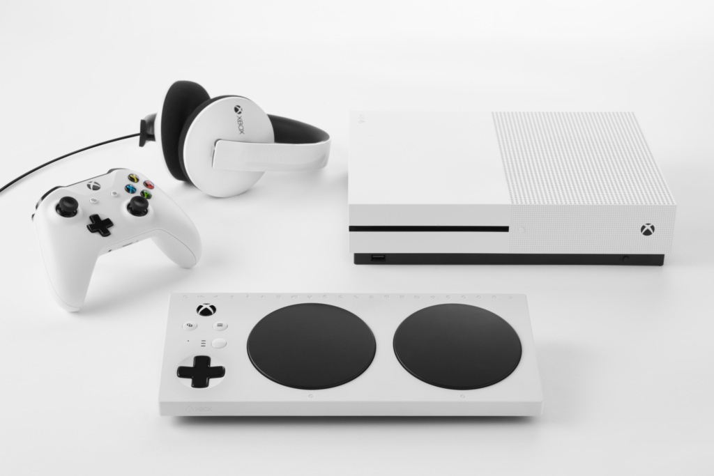 A Xbox controller, Xbox headset, and an Xbox One S neatly arranged, all white in color, with a white Xbox Adaptive Controller displayed in front. - click to enlarge A Xbox controller, Xbox headset, and an Xbox One S neatly arranged, all white in color, with a white Xbox Adaptive Controller displayed in front.